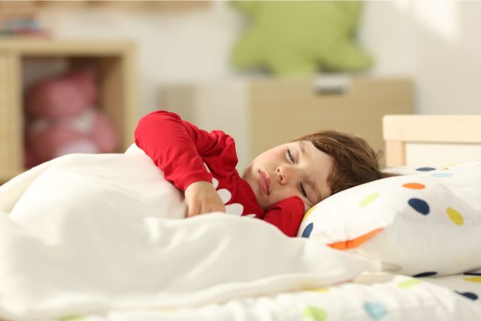 toddler sleeping in bed